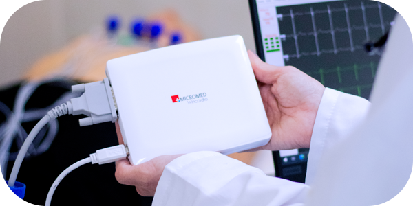 Cardiologista segurando o Wincardio Micromed enquanto realiza exame em paciente, apoiando no diagnóstico precoce.